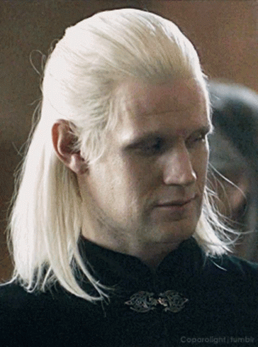 a man with blonde hair is wearing a black shirt and a black collar