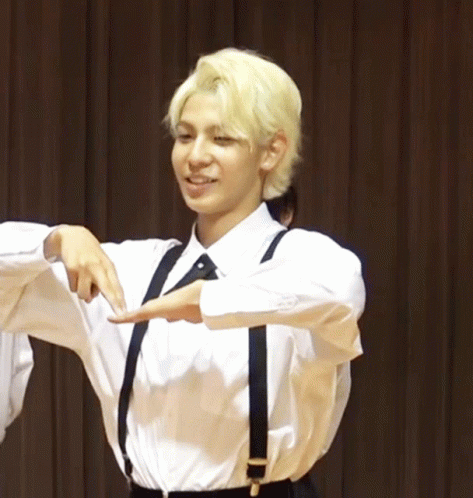 A Man With Blonde Hair Wearing Suspenders And A White Shirt Smiles GIF