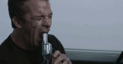 A Man With Blood On His Face Is Biting A Gun In His Mouth . GIF