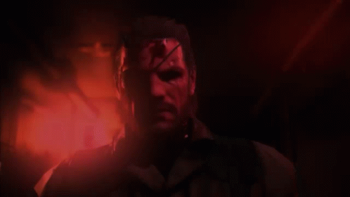 A Man With Blood On His Face Stands In A Dark Room GIF