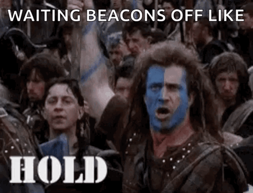 A Man With Blue And White Paint On His Face Is Standing In Front Of A Crowd Of People . GIF