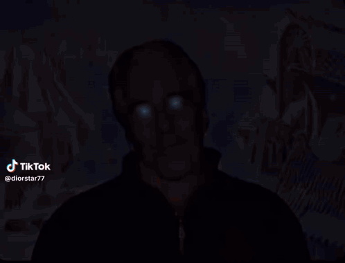 A Man With Blue Eyes Is Standing In Front Of A Painting With A Star Of David In The Background GIF