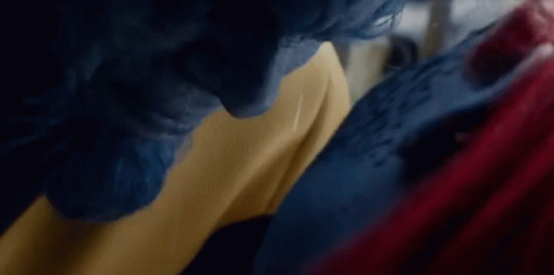 A Man With Blue Hair And A Woman With Red Hair Are Standing Next To Each Other . GIF