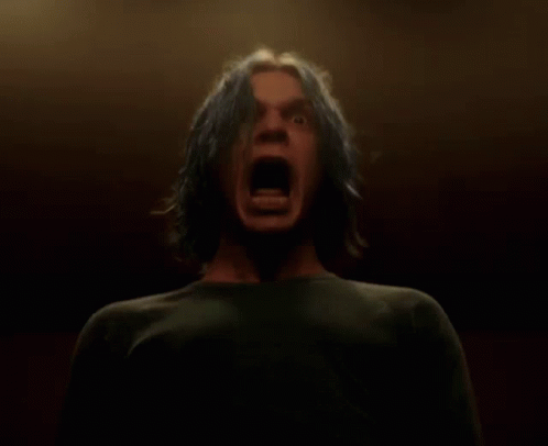 A Man With Blue Hair Is Screaming Into The Camera GIF