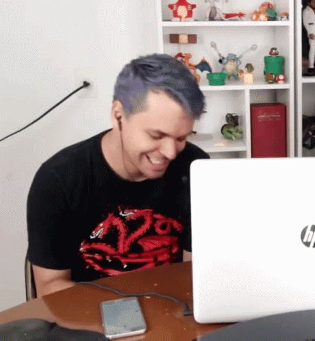 A Man With Blue Hair Is Sitting In Front Of An Hp Laptop . GIF