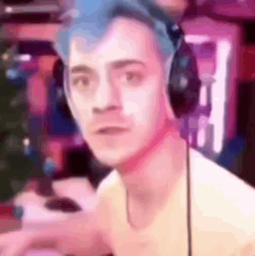 A Man With Blue Hair Is Wearing Headphones And Looking At The Camera In A Blurry Photo . GIF