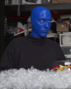 A Man With Blue Paint On His Face Is Sitting In Front Of A Pile Of Ice GIF