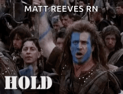 A Man With Blue Paint On His Face Is Standing In Front Of A Crowd Of People And Says Hold . GIF