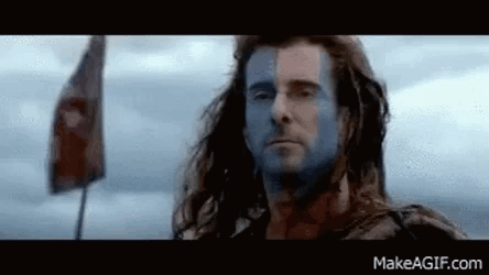 Man With Blue Face Paint Standing In Front Of Flag GIF