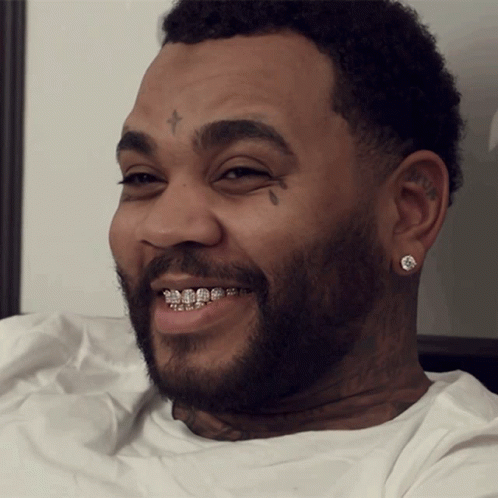 A Man With Braces On His Teeth Has A Cross On His Forehead GIF