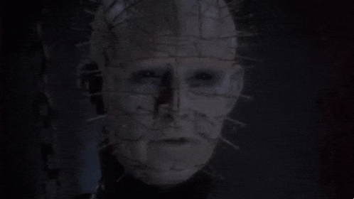 A Man With Chains Around His Neck Is Looking At The Camera GIF