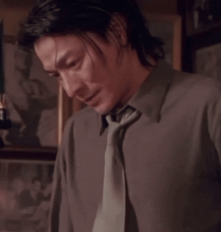 A Man With Chinese Writing On His Shirt And Tie GIF