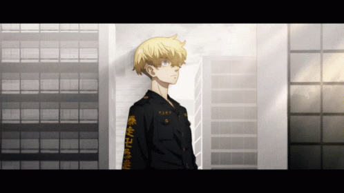 A Man With Chinese Writing On His Sleeve Stands In Front Of A Tall Building GIF