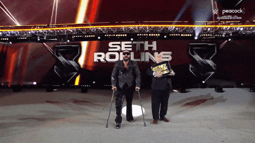 A Man With Crutches Stands In Front Of A Peacock Logo GIF