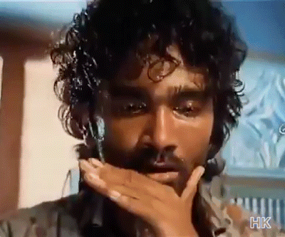 A Man With Curly Hair And A Beard Covering His Mouth With His Hand .. GIF