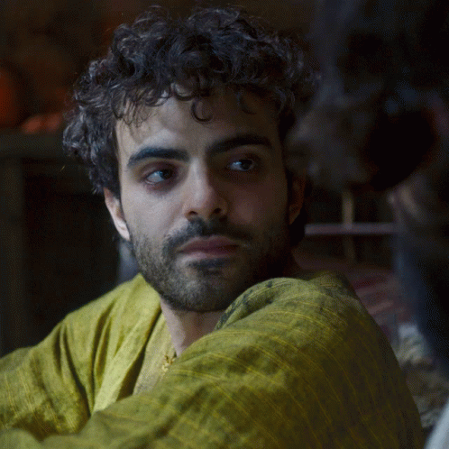 A Man With Curly Hair And A Beard In A Yellow Shirt GIF