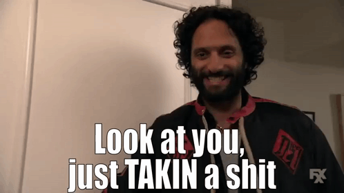 A Man With Curly Hair And A Beard Is Smiling And Saying Look At You Just Takin A Shit GIF