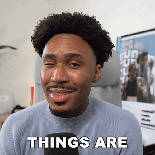 A Man With Curly Hair And A Beard Is Smiling And Says Things Are GIF