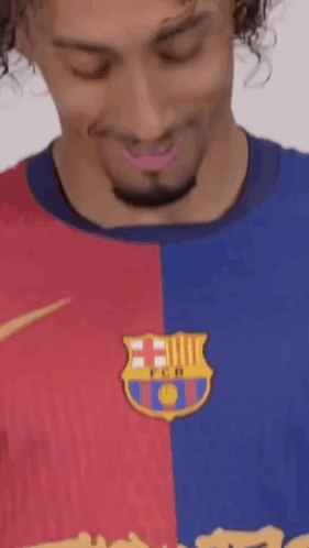 A Man With Curly Hair And A Beard Is Wearing A Barcelona Shirt . GIF