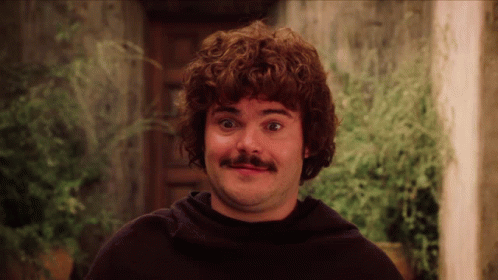 A Man With Curly Hair And A Mustache Is Making A Face GIF