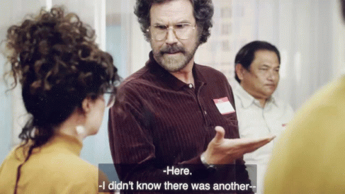 A Man With Curly Hair And Glasses Is Talking To A Woman Who Says Here I Did N't Know There Was Another GIF