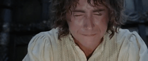 A Man With Curly Hair Is Crying With His Eyes Closed And His Mouth Open . GIF