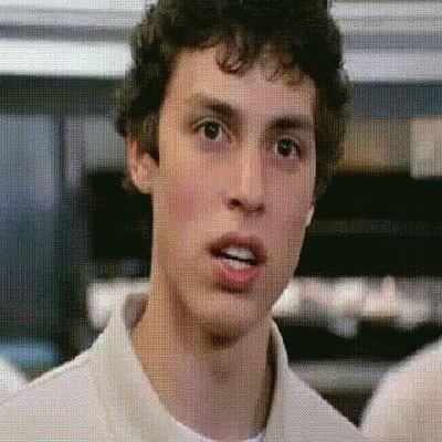A Man With Curly Hair Is Making A Funny Face GIF