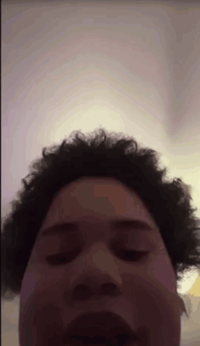 A Man With Curly Hair Is Making A Funny Face GIF