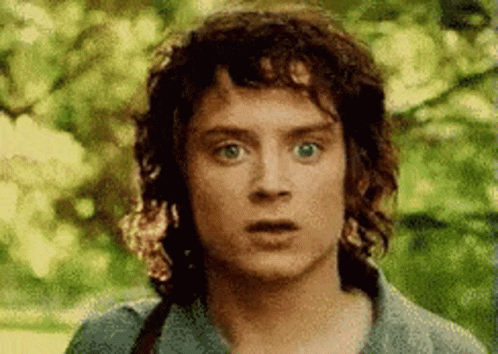 A Man With Curly Hair Is Making A Surprised Face . GIF