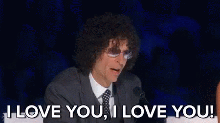 A Man With Curly Hair Is Sitting In Front Of A Microphone And Saying `` I Love You , I Love You '' GIF