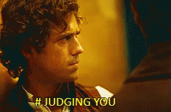A Man With Curly Hair Is Talking To Another Man And Says # Judging You . GIF