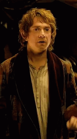 A Man With Curly Hair Is Wearing A Brown Jacket GIF