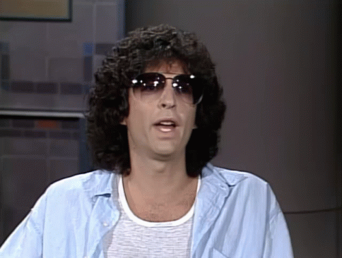 A Man With Curly Hair Is Wearing Sunglasses And A Light Blue Shirt GIF