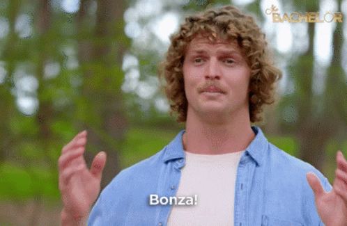 Man With Curly Hair Saying Bonza In Front Of Bachelor Logo GIF