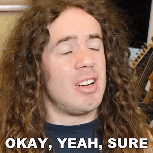 A Man With Curly Hair Says Okay Yeah Sure In Front Of A Guitar GIF