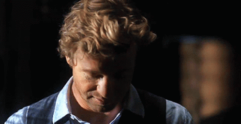 A Man With Curly Hair Wearing A Blue Shirt And Vest GIF