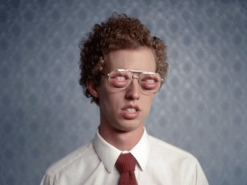 a man with curly hair wearing glasses and a red tie