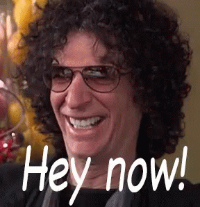 A Man With Curly Hair Wearing Glasses Is Smiling And Saying Hey Now . GIF