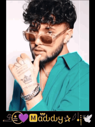 A Man With Curly Hair Wearing Sunglasses And A Purple Heart With The Word Maddy On It GIF