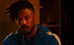 A Man With Dreadlocks And A Beard Is Wearing A Blue Jacket GIF