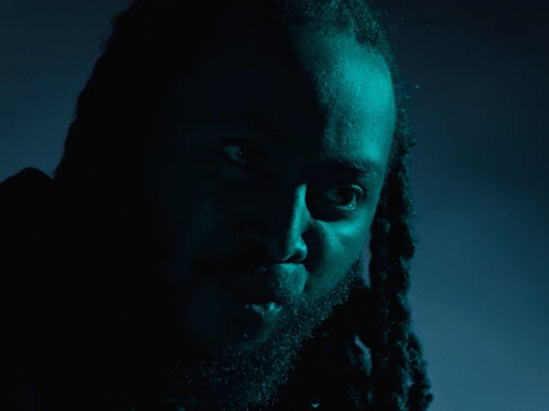 a man with dreadlocks and a beard says what in yellow