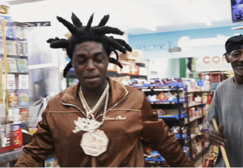 A Man With Dreadlocks And A Necklace That Says $ 100,000 On It GIF