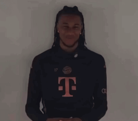 a man with dreadlocks and a t-mobile shirt is laughing