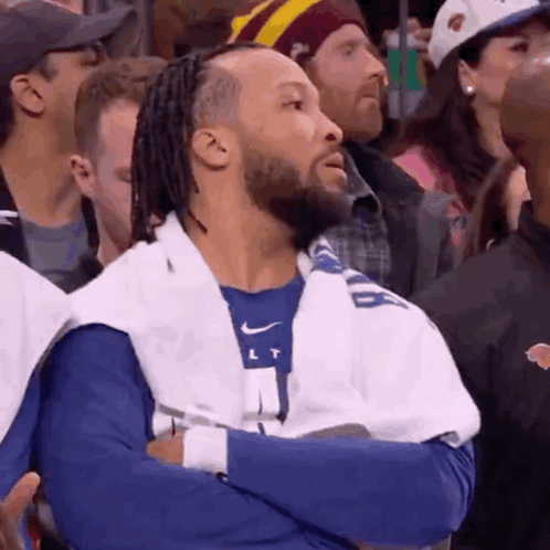 A Man With Dreadlocks And A Towel Around His Neck Is Watching A Basketball Game GIF