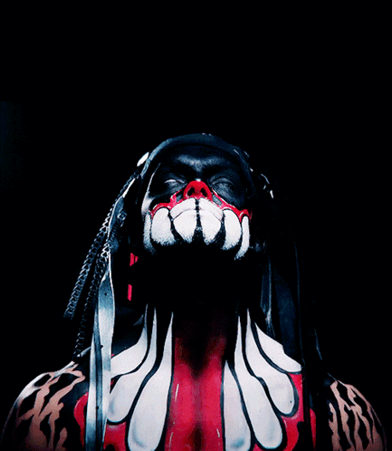 A Man With Dreadlocks And Red And White Paint On His Body GIF