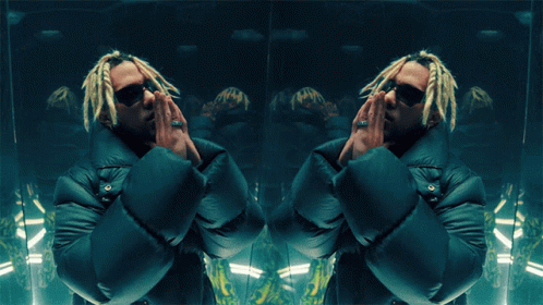 A Man With Dreadlocks And Sunglasses Is Standing In Front Of A Mirror GIF
