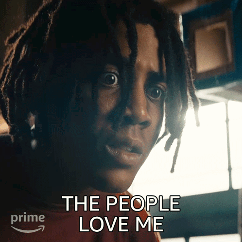 A Man With Dreadlocks Has The Words " The People Love Me " Above His Head GIF