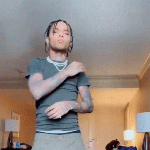 A Man With Dreadlocks Is Dancing In A Room . GIF