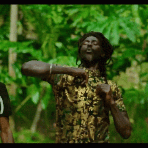 A Man With Dreadlocks Is Dancing In The Jungle . GIF