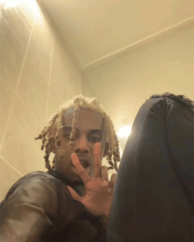 A Man With Dreadlocks Is Giving The Peace Sign GIF